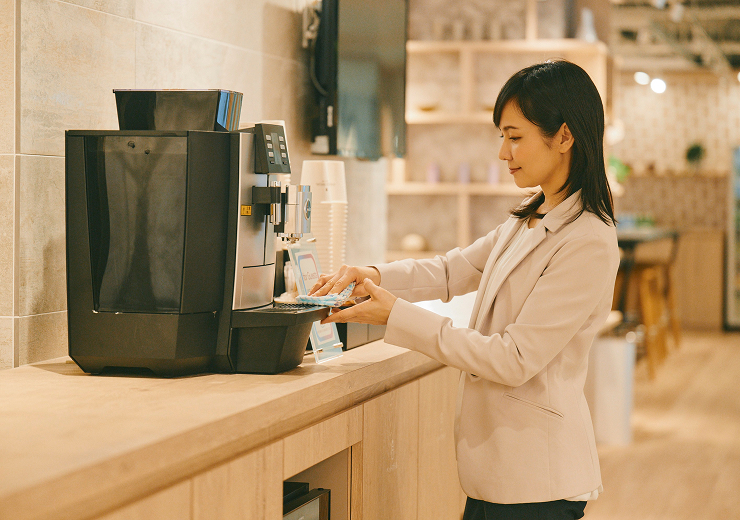 コンシェルジュスタッフがコーヒーマシーンを拭いている写真