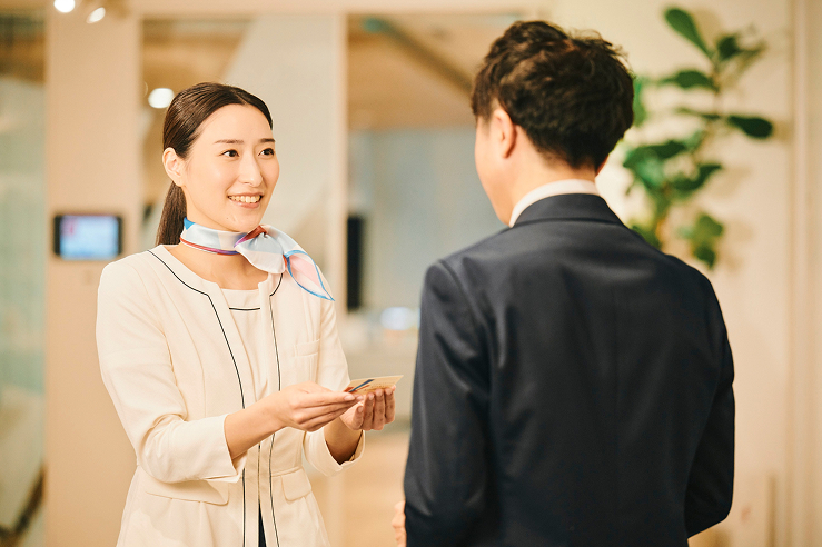 受付スタッフが名刺をお預かりしている写真