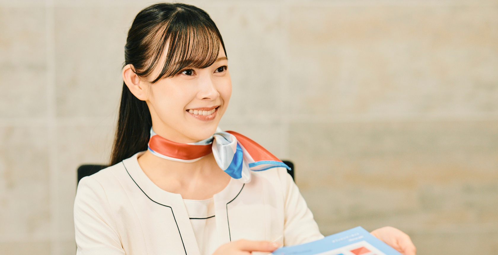 受付スタッフが着座してカタログを案内している写真